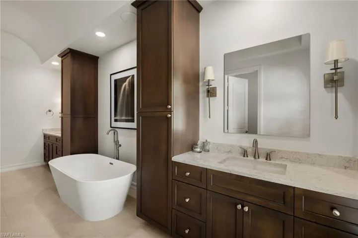 Bathroom with vanity, a bath, and tile patterned floors