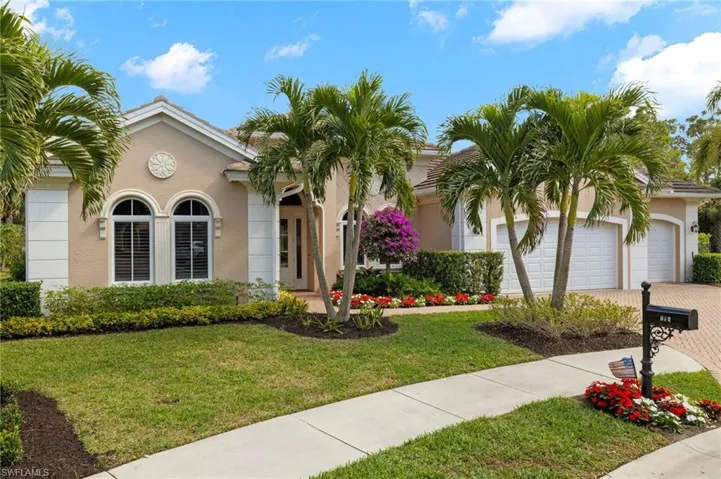 View of front of property with a garage and a front lawn