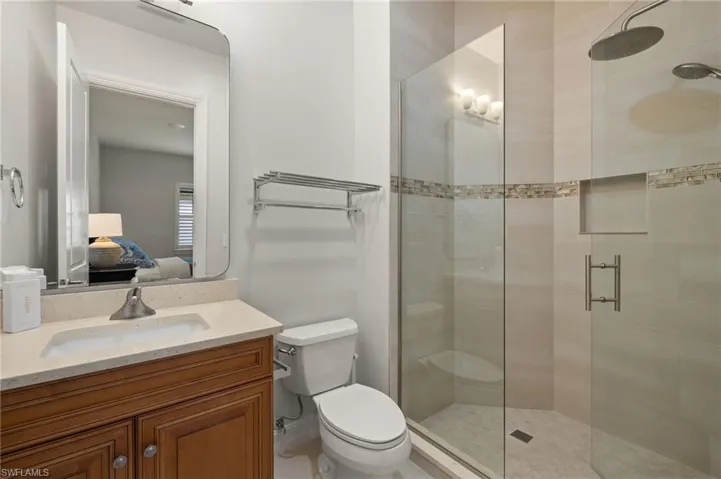 Bathroom with an enclosed shower, vanity, and toilet