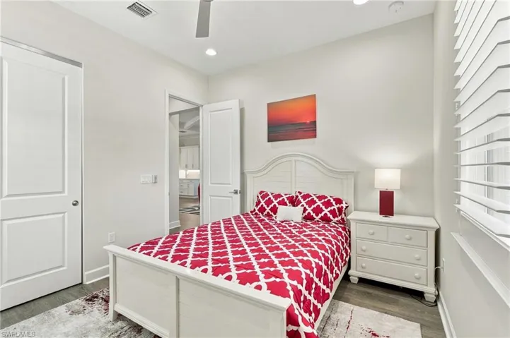 Recessed lighting, ceiling fan, wood-finish flooring, white panel doors, and window with white blinds