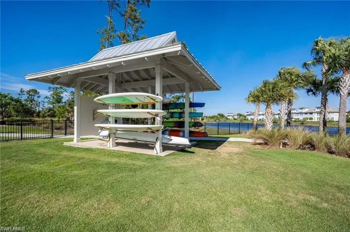Covered outdoor storage structure featuring a metal roof and painted wood columns