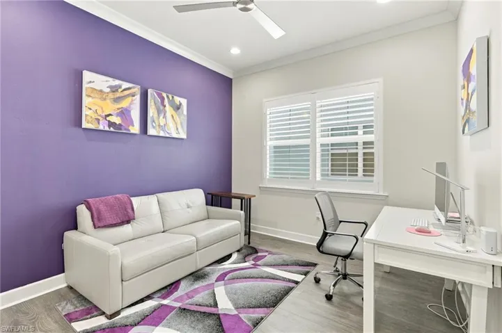 Wood-finish flooring, crown molding, recessed lighting, ceiling fan, and window with plantation shutters