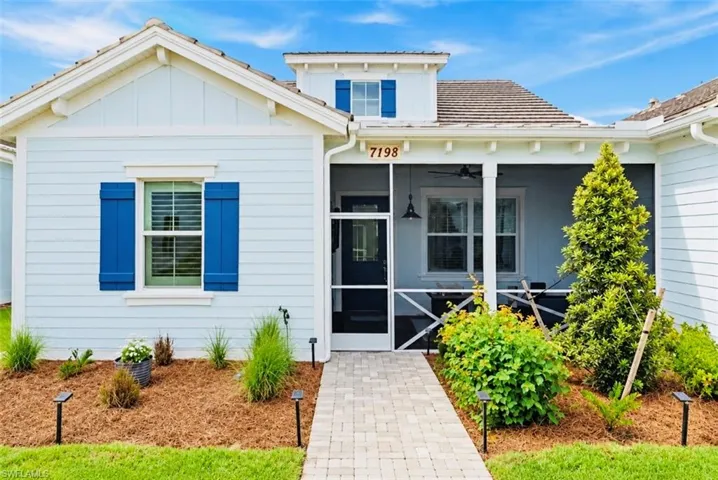 Light blue siding exterior with white trim and blue shutters, dormer with blue shutters, screened porch with ceiling fan and hanging light fixture, paved walkway, and landscaped front yard