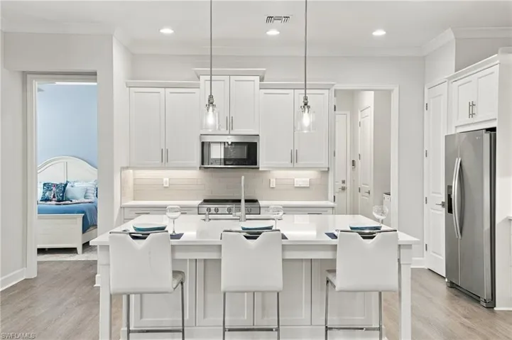 Gourmet kitchen featuring a center island with seating, stainless steel appliances, recessed lighting, and wood-finish flooring
