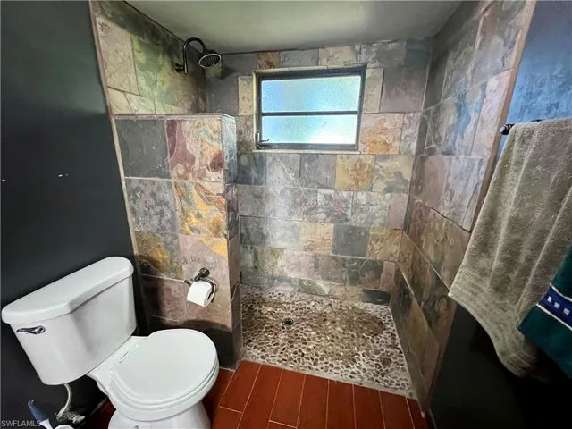 Primary Bathroom with toilet and a tile shower