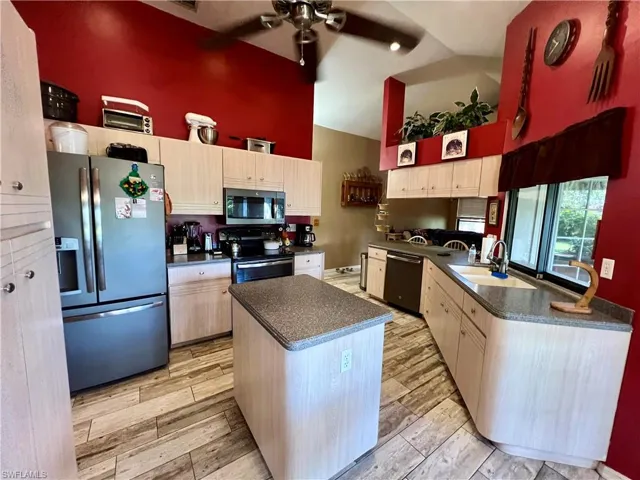 Kitchen with stainless steel appliances, ceiling fan, sink, and wood plank tile floors