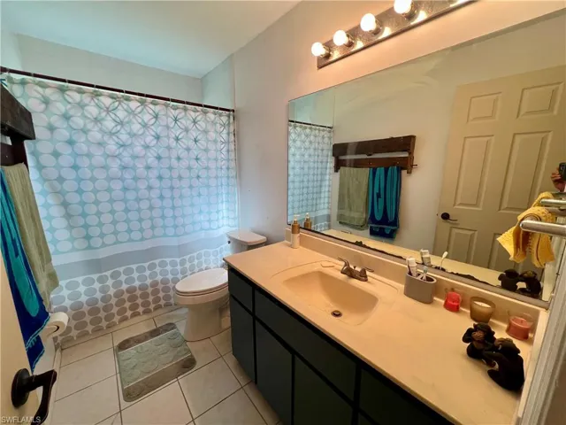 Bathroom featuring vanity, tile patterned flooring, and toilet