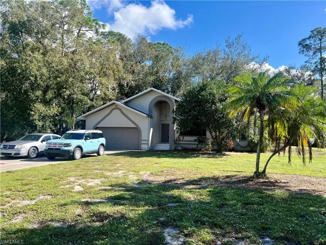 View of front of home with a garage and a front lawn