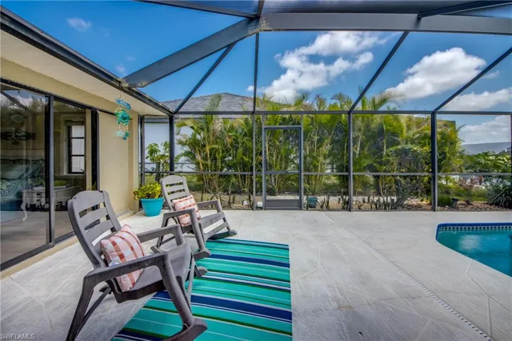 View of patio with an outdoor pool and glass enclosure