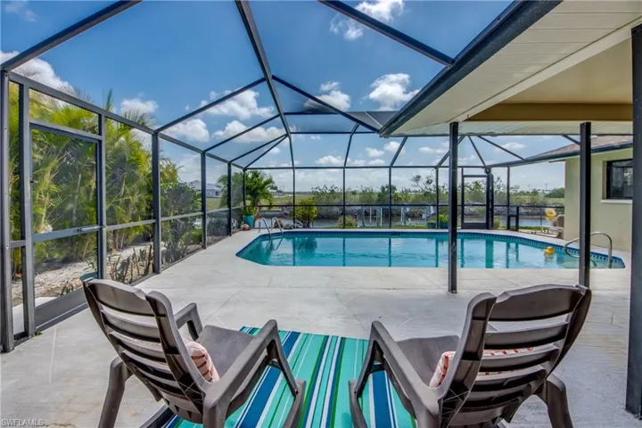 Outdoor pool featuring a patio area and glass enclosure