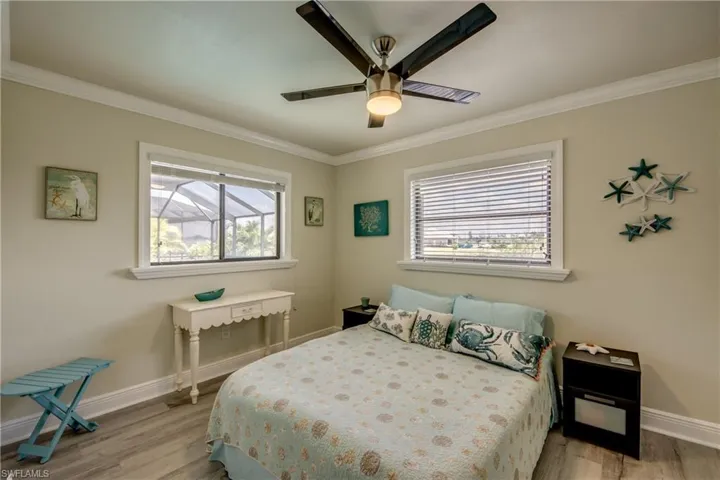 Bedroom with light wood-style flooring, crown molding, and baseboards