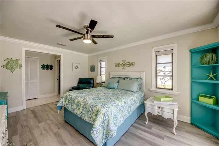 Bedroom featuring crown molding, visible vents, and wood finished floors
