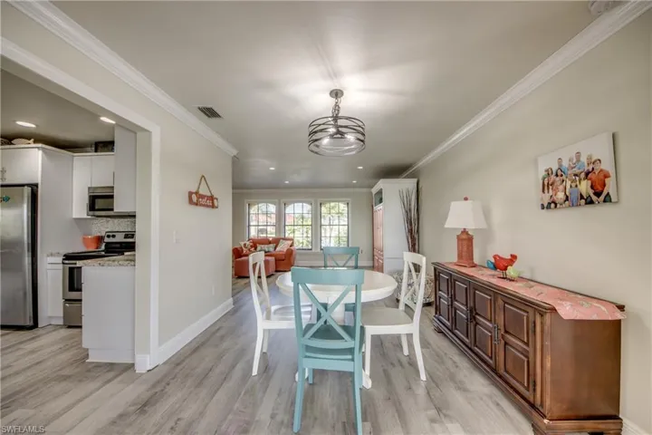 Dining space featuring ornamental molding, visible vents, and light wood-style floors