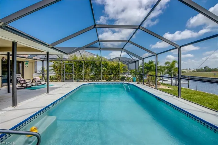 Pool with a patio and glass enclosure