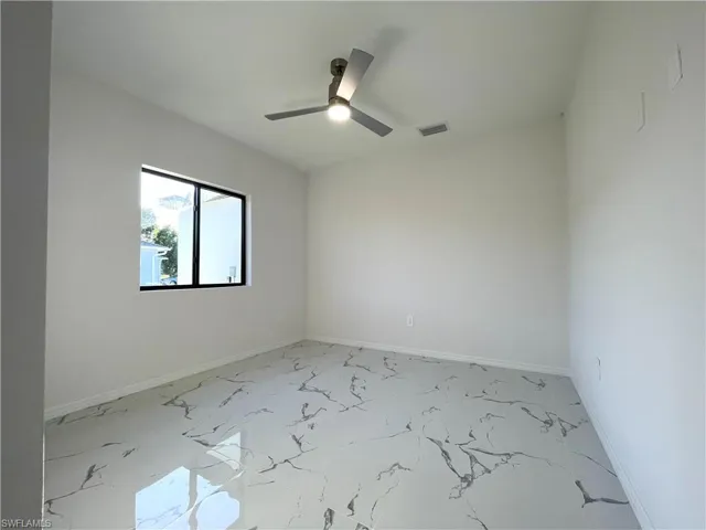 Empty room with light marble finish flooring and ceiling fan