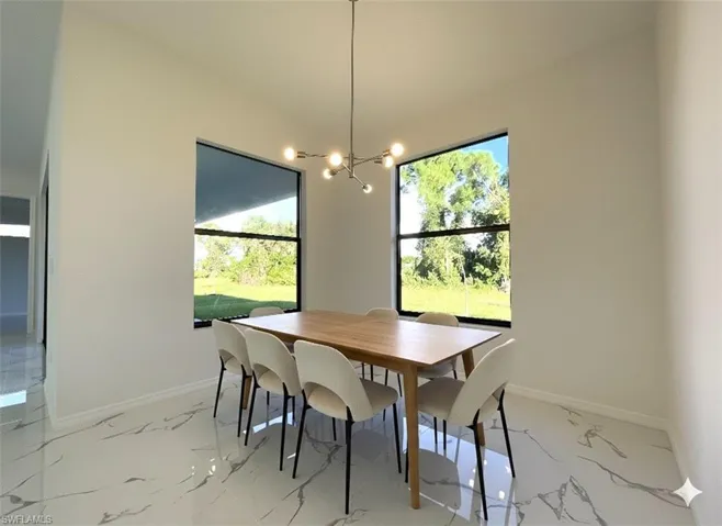 Dining space with a chandelier and light marble finish flooring