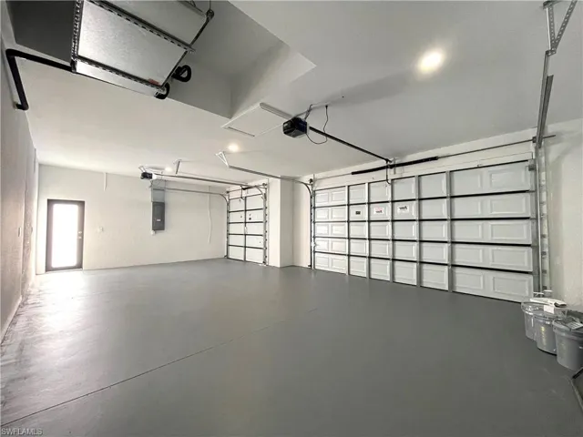 Garage with electric panel and a garage door opener