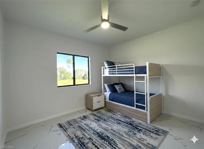 Unfurnished bedroom with light marble finish flooring and ceiling fan