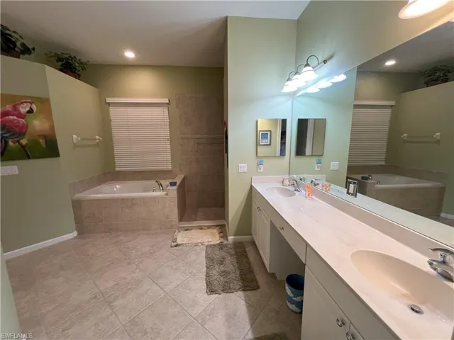 Dual vanity with integrated sinks, a large mirror, and overhead strip lighting