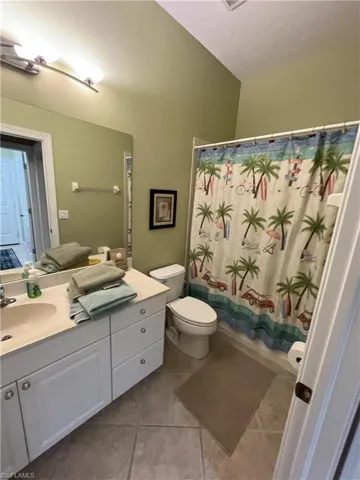 Bathroom featuring a single vanity with a white cabinet, light-colored countertop, and integrated sink