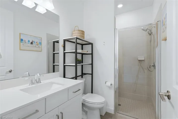 Bathroom featuring a white vanity with an integrated sink, polished chrome faucet, and a large wall-mounted mirror