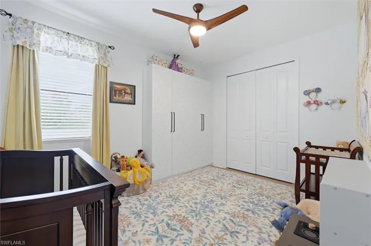 Room featuring a contemporary ceiling fan, window with blinds and drapes, and wood-finish flooring