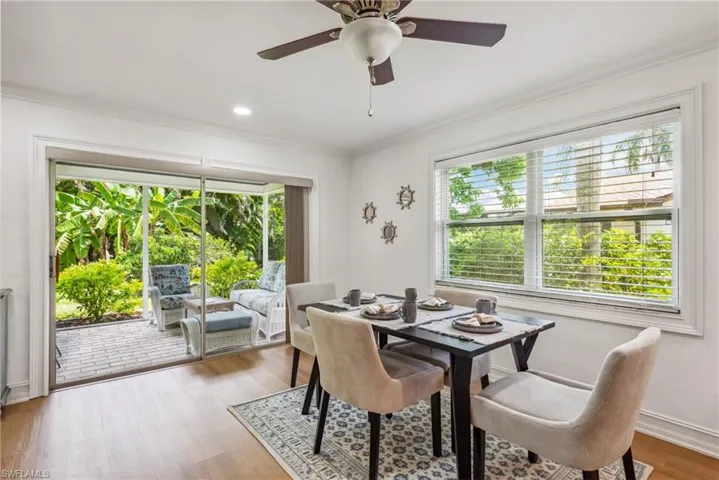 Dining space with a wealth of natural light, ceiling fan, light wood-type flooring, and crown molding