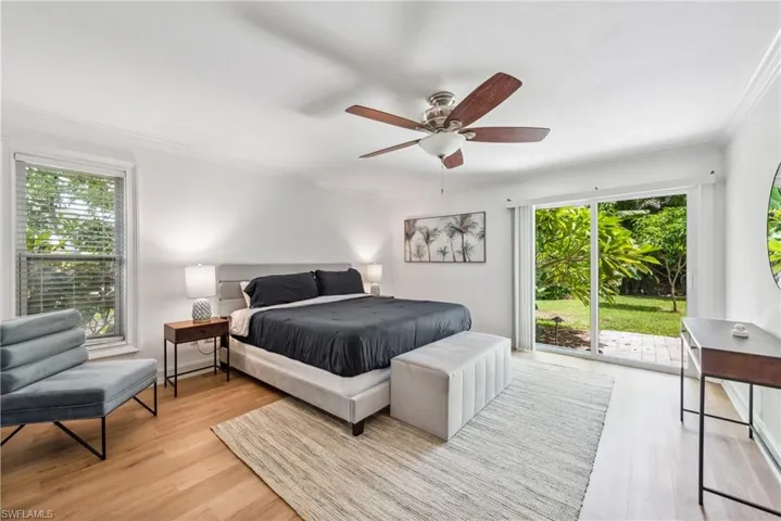 Bedroom with ceiling fan, access to exterior, ornamental molding, and light hardwood / wood-style floors