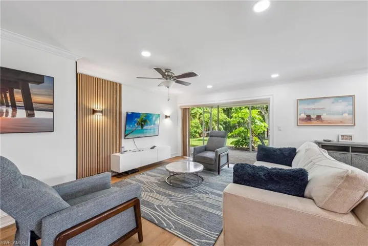 Living room with ceiling fan, ornamental molding, and hardwood / wood-style floors