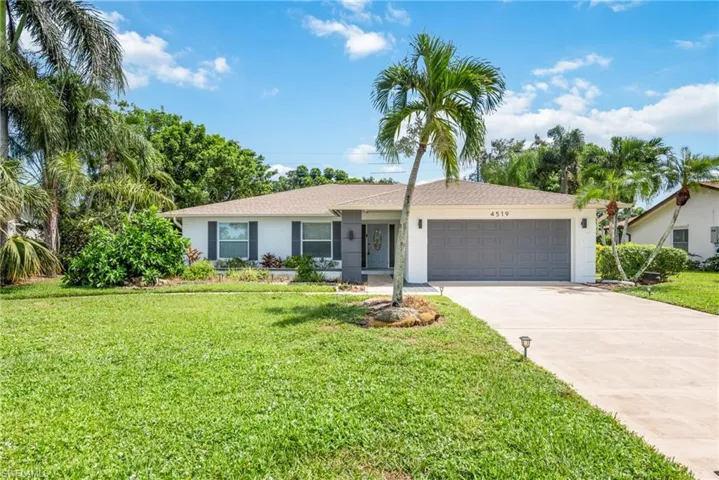 Single story home featuring a garage and a front yard