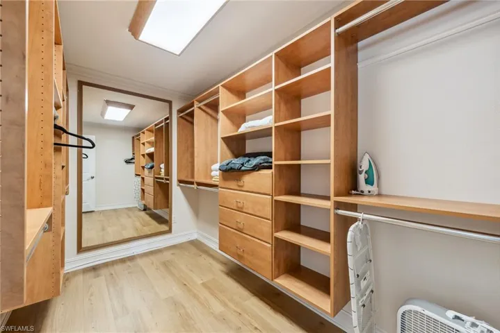 Spacious closet with light hardwood / wood-style floors