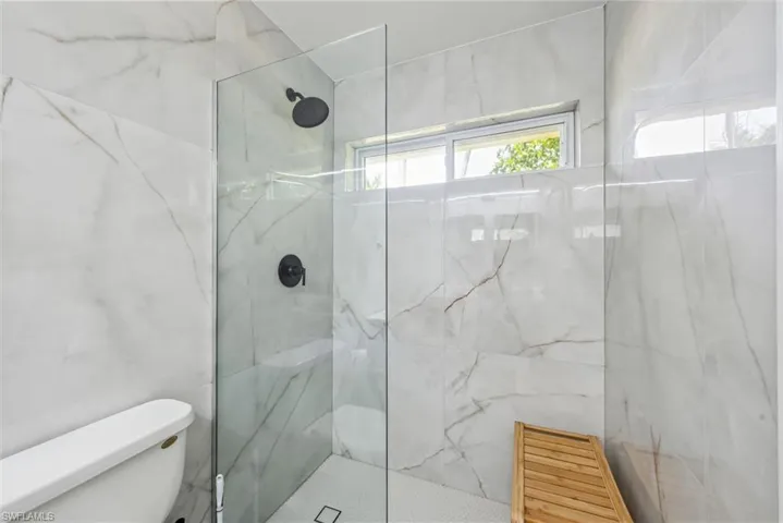 Bathroom featuring a tile shower and toilet