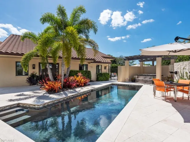 Swimming pool with a jacuzzi, a fenced backyard, a patio, a gate, and outdoor dining space