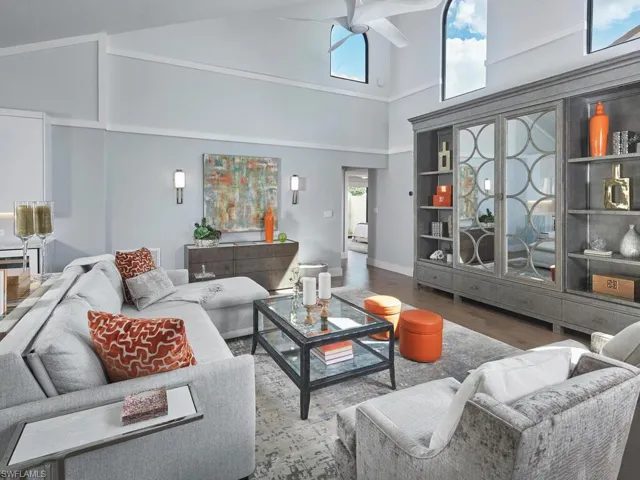 Living room featuring high vaulted ceiling, wood finished floors, a ceiling fan, and plenty of natural light