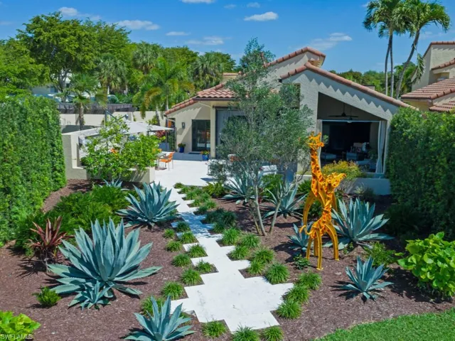 Rear view of house with a tile roof, stucco siding, and a patio area