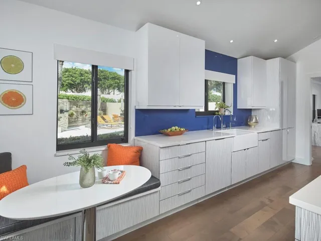 Kitchen featuring dark wood finished floors, modern cabinets, white cabinets, decorative backsplash, and recessed lighting