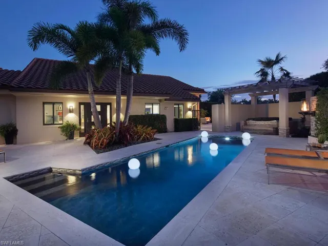 Pool at dusk with an outdoor pool, a pergola, a jacuzzi, and a patio area
