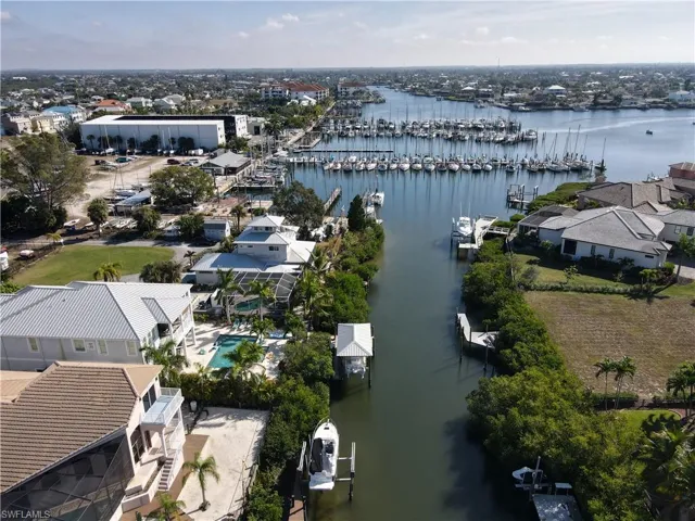 Drone / aerial view of canal behind home leading to marina area and out to Tampa Bay