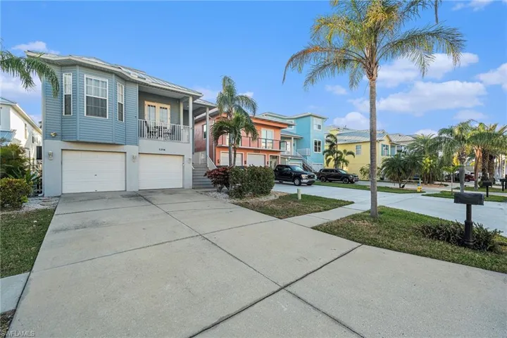 Coastal home featuring driveway, a residential view, and a garage