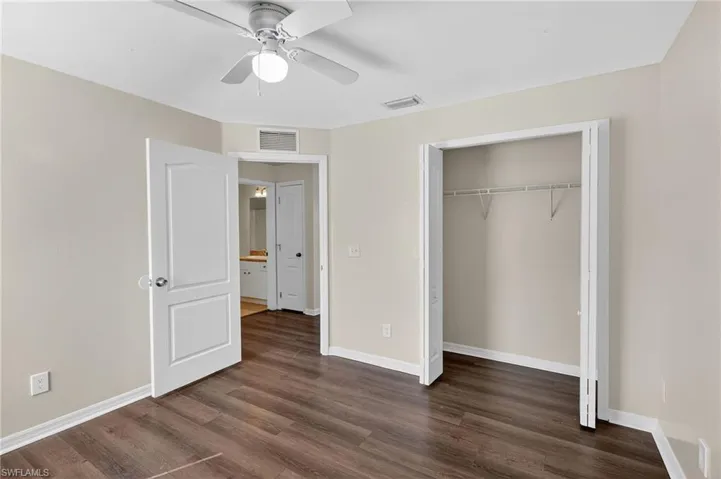 Unfurnished bedroom with dark wood finished floors, ceiling fan, and a closet