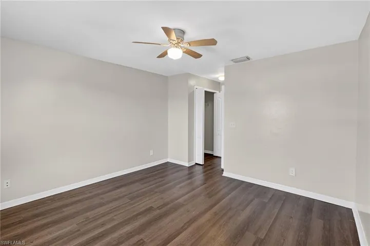 Unfurnished room featuring ceiling fan and dark wood finished floors