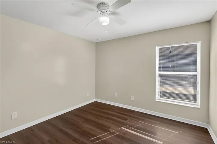 Spare room with dark wood-style floors and ceiling fan