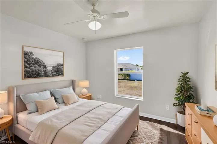 Bedroom with dark wood finished floors and a ceiling fan