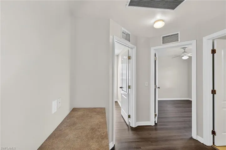 Hall with dark wood finished floors and baseboards