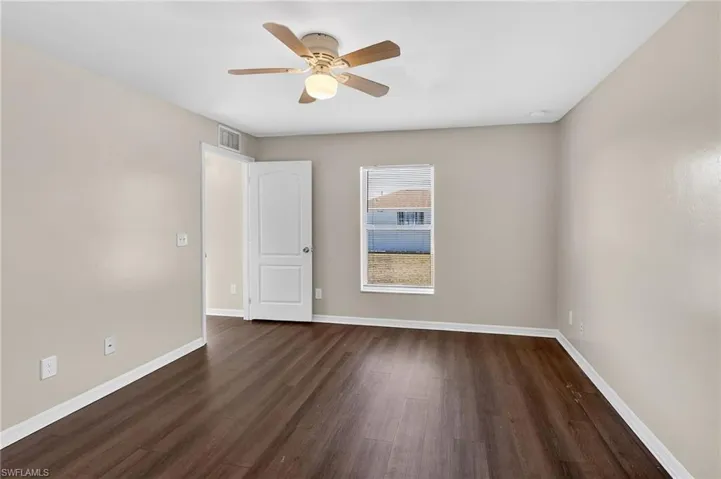 Spare room with dark wood finished floors and ceiling fan