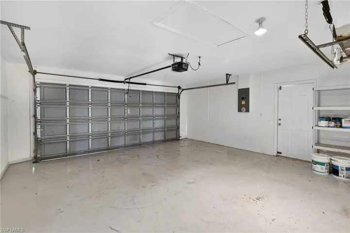 Garage with electric panel and a garage door opener