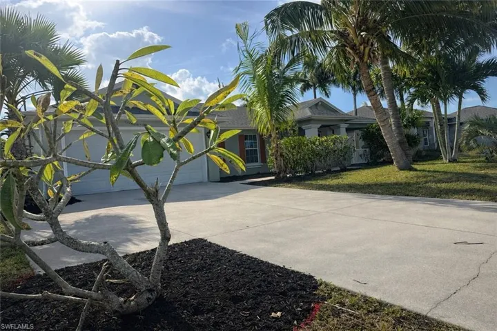 View of front facade with driveway and a front lawn