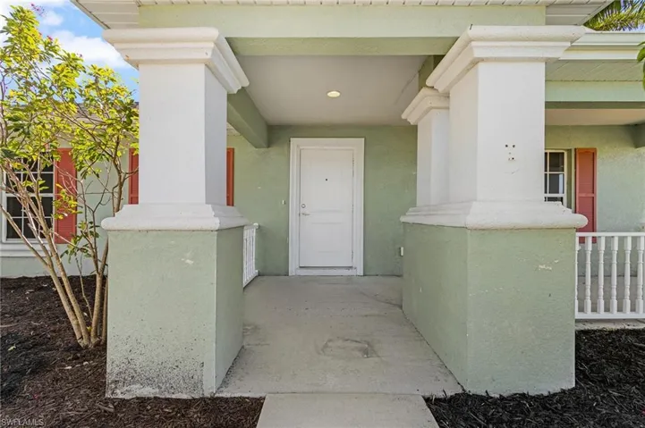 Doorway to property with stucco siding and a porch