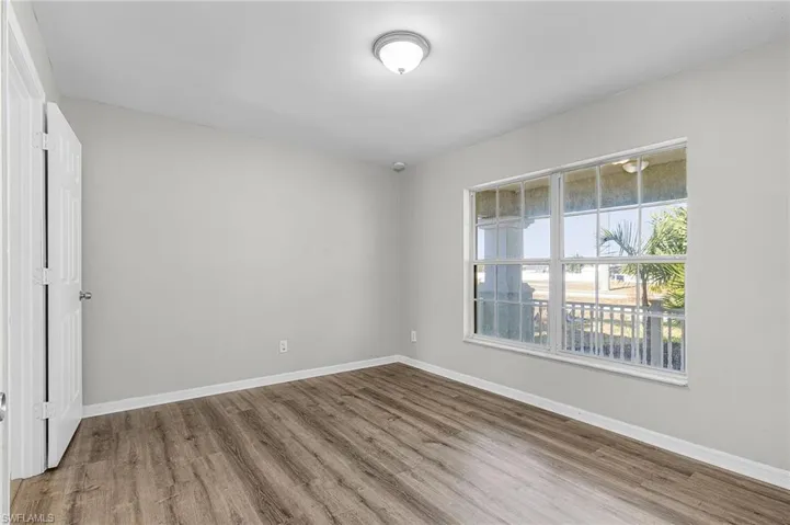 Empty room with baseboards and light wood-style flooring