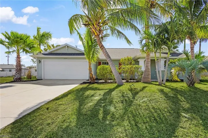 Ranch-style home with concrete driveway, an attached garage, a front yard, and stucco siding